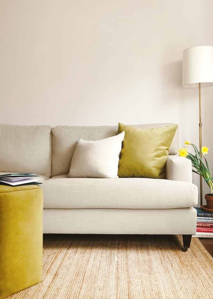 Classic sofa in husk linen in a living room with pillows and ottoman