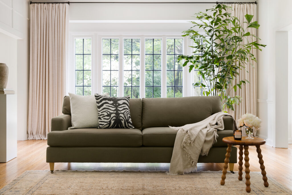 Classic sofa in olive linen in a living room with decorative pillows